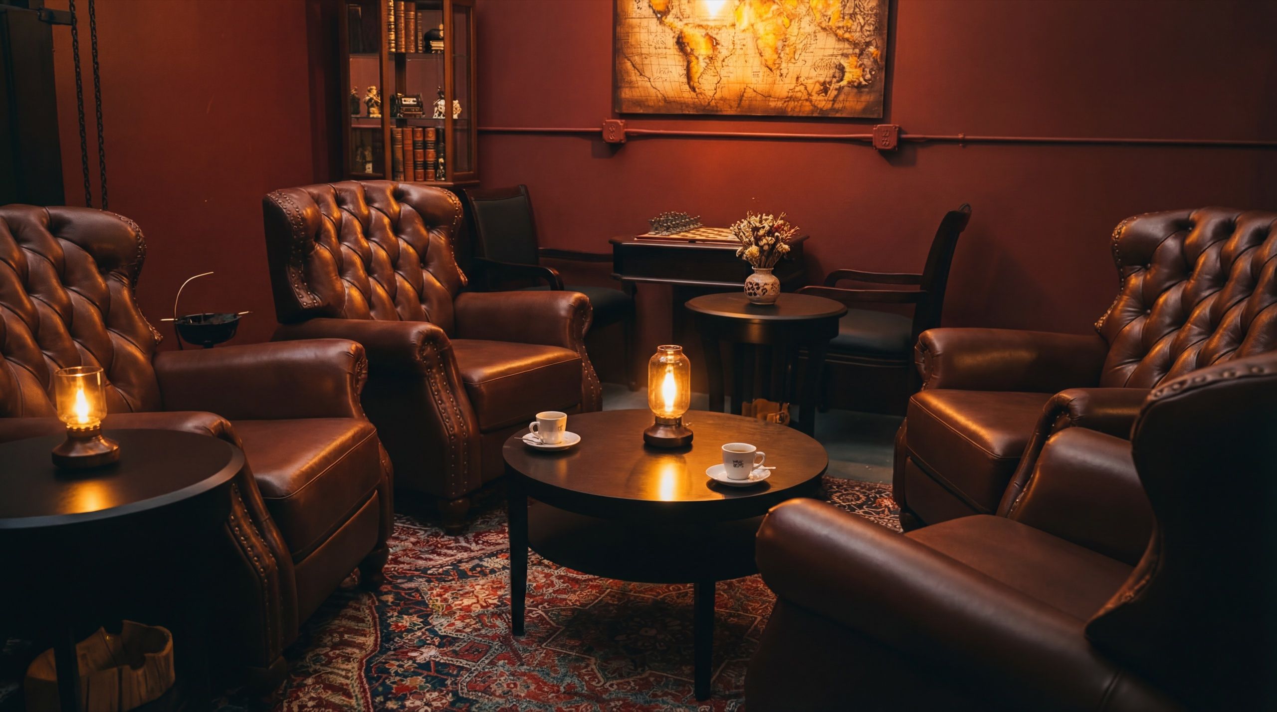 Private event setup at Cuban Social Club with wingback leather chairs, chess table, and warm ambient lighting